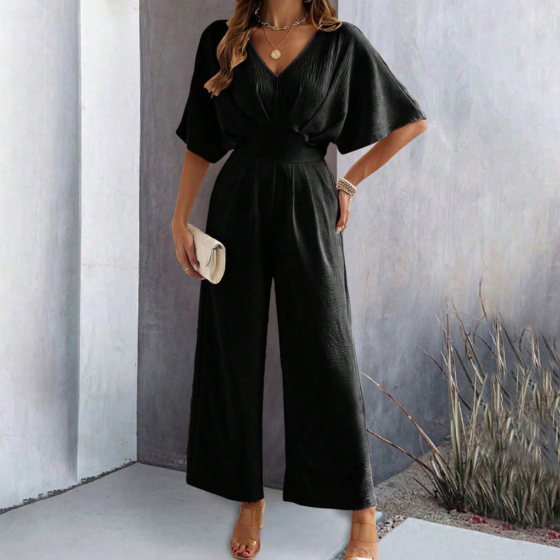 Modieuze dames jumpsuit met diepe V-hals en brede wijde pijpen, creëert een slank en stijlvol silhouet.