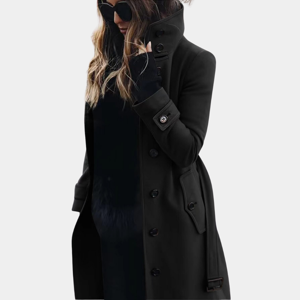 Modieuze dames trenchcoat met een lange pasvorm, verstelbare riem en beschermende hoge kraag. Geschikt voor koudere dagen.