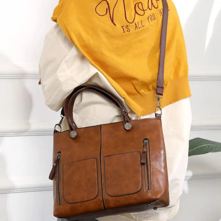 Model draagt een elegante leren schoudertas voor dames. Stijlvolle en praktische handtas als finishing touch bij de outfit.