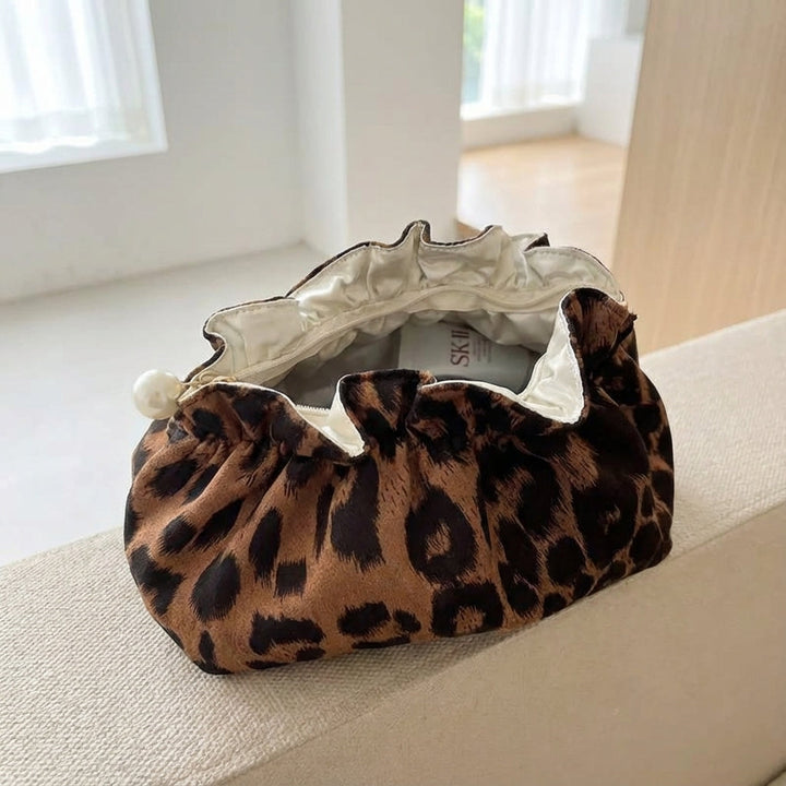 Stijlvolle cosmetische reistasje met ruches en parel accenten; perfect voor make-up en accessoires onderweg.