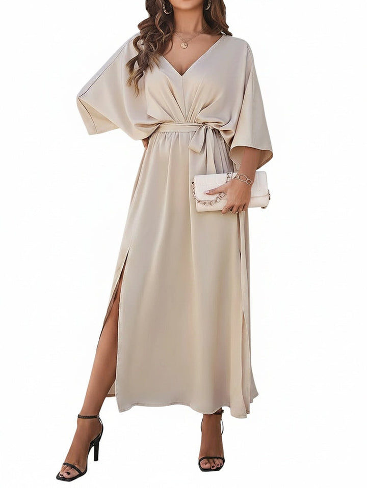Elegante dames maxi jurk met V-hals, vleermuismouw, strikceintuur en hoge split. Perfect voor avondjes uit.