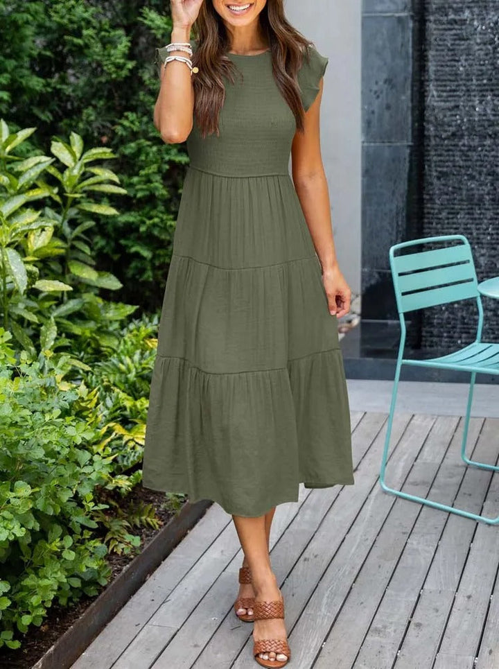 Flatterende dames zomerjurk, midi lengte met elegante vlindermouwen, geschikt als strandjurk of casual outfit.