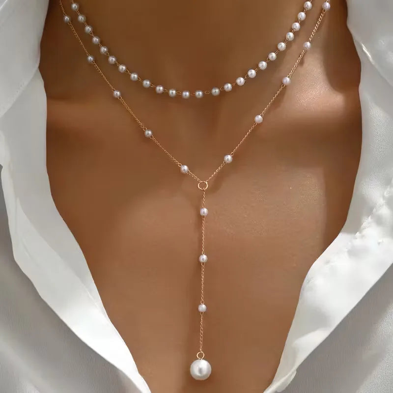 Elegante dames Y-vormige goudkleurige ketting met glanzende parels; een chic mode sieraad.