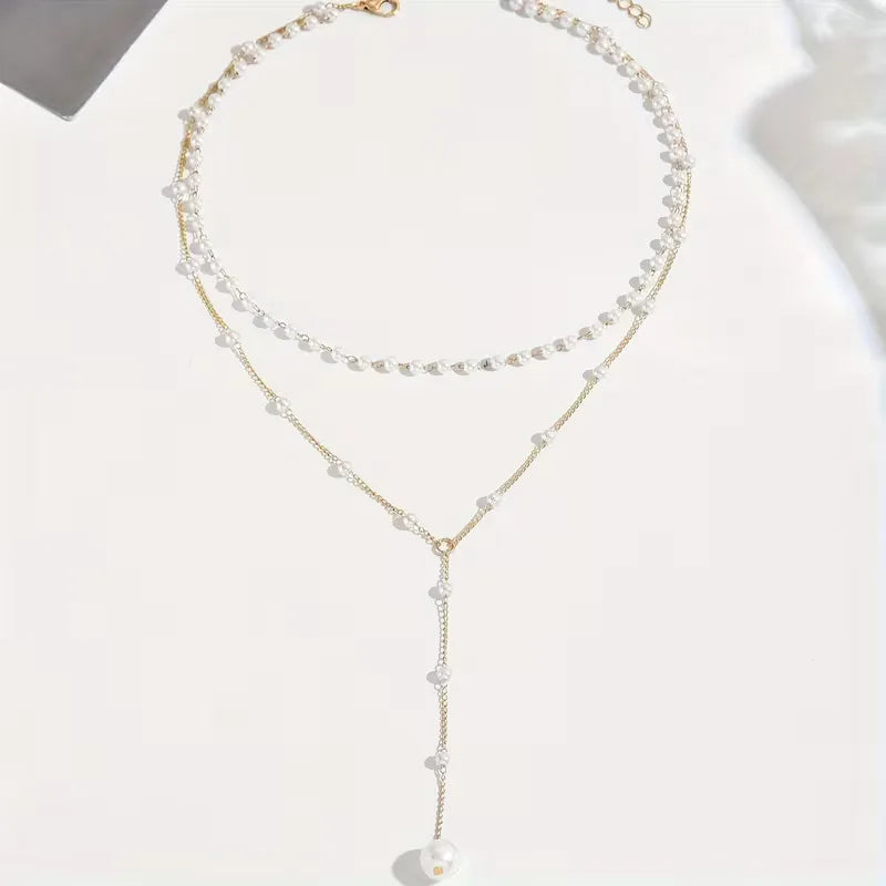 Goudkleurige Y-vormige ketting voor dames met glanzende parels; een elegant sieraad.