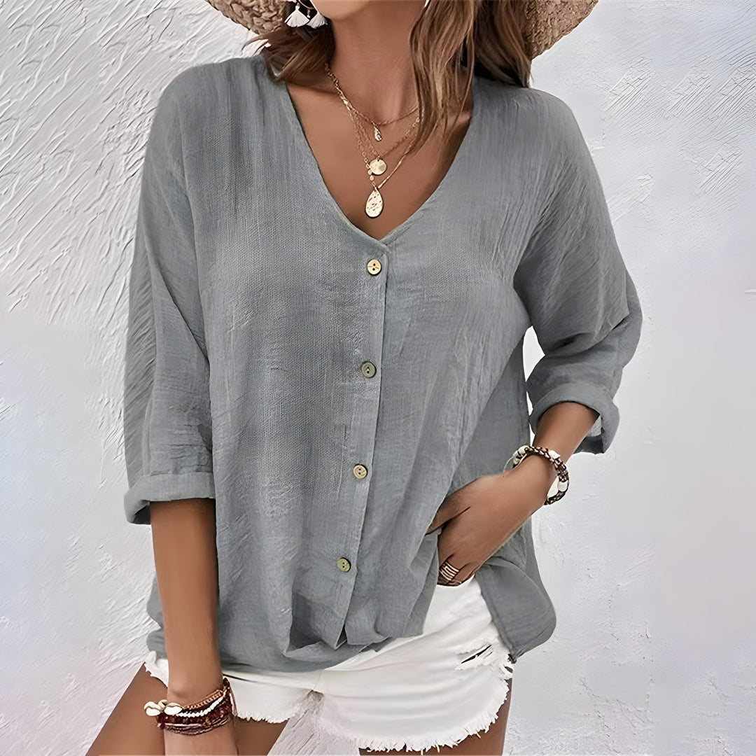 Damesblouse met elegante V-hals, 3/4 mouw en subtiele knoopsluiting. Casual, comfortabele en veelzijdige mode.
