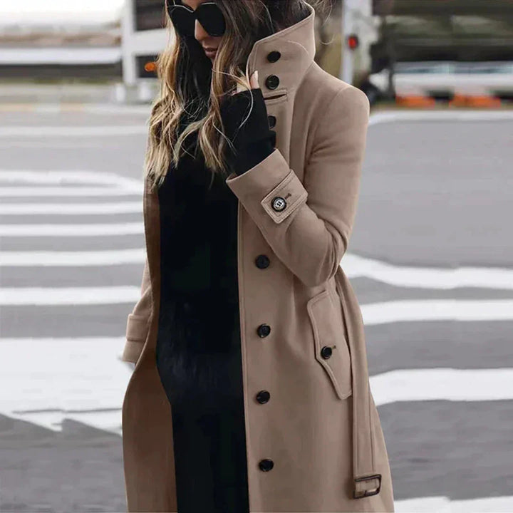 "Elegante damestrenchcoat met hoge kraag, ceintuur en dubbele knoopsluiting, zijaanzicht voor een modieuze uitstraling."
