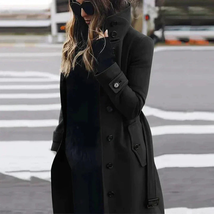 "Elegante damestrenchcoat met hoge kraag, ceintuur en dubbele knoopsluiting, zijaanzicht voor een modieuze uitstraling."