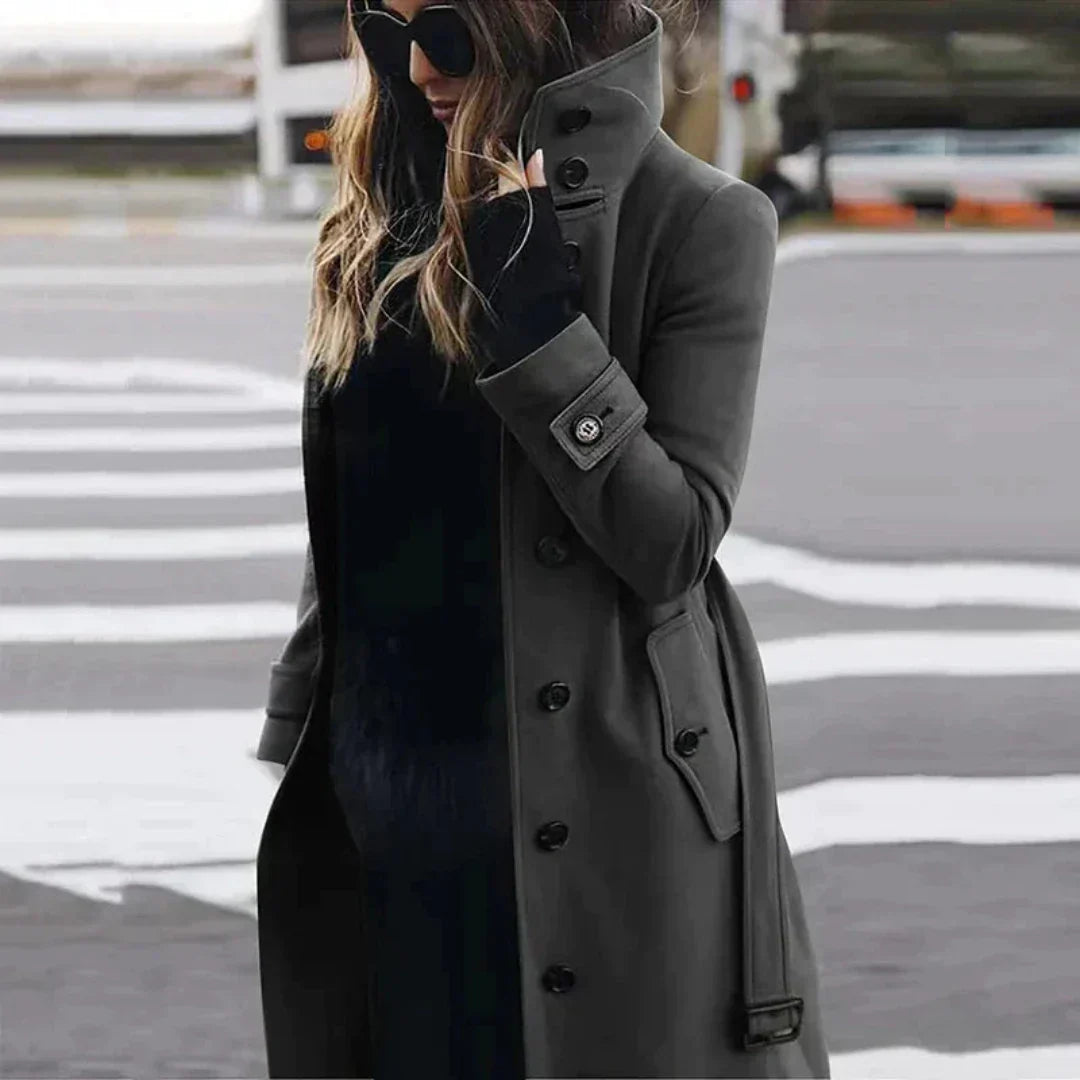 "Elegante damestrenchcoat met hoge kraag, ceintuur en dubbele knoopsluiting, zijaanzicht voor een modieuze uitstraling."