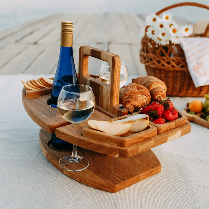 Detailopname eiken picknicktafel met uitsparingen voor wijnflessen, glazen & hapjes. Essentieel voor zomerse avonden.
