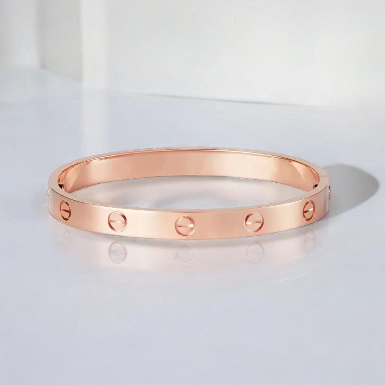 "Elegante gouden armband met tijdloos design en schroefdetails, een verfijnd en luxueus accessoire voor elke gelegenheid."