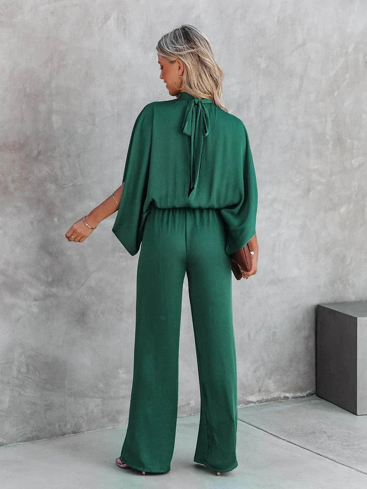 Chique groene dames jumpsuit met capemouwen, trendy avondkleding voor een feestelijke gelegenheid.
