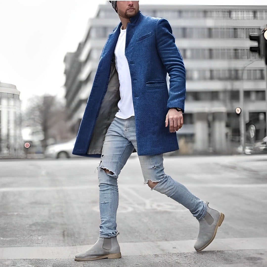 Modieuze lange heren overjas met verfijnde knoopsluiting. Een warme en elegante keuze voor koude dagen.