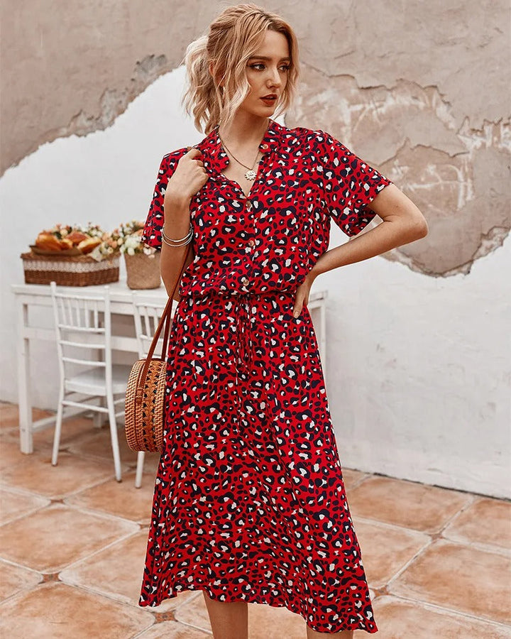 "Elegante midi zomerjurk met kleurrijke bloemenprint, korte mouwen, marineblauw en rood, luchtig en comfortabel."