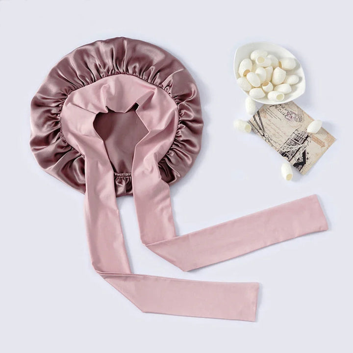 "Elegante moerbeizijden slaapmuts voor vrouwen met verstelbare band, close-up op luxe materiaal en satijnen afwerking."