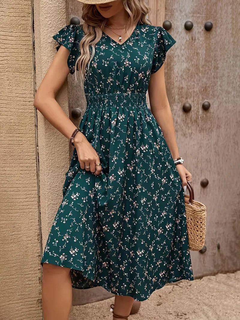 Elegante petrol A-lijn damesjurk met verfijnde bloemenprint, perfect voor zomerse dagen. Midi-lengte, V-hals.