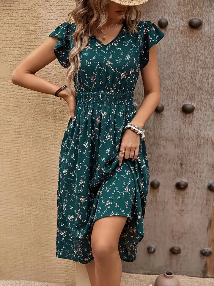Stijlvolle petrol A-lijn jurk voor dames, met elegante bloemenprint. Midi-lengte, V-hals en fluttermouwen voor de zomer.