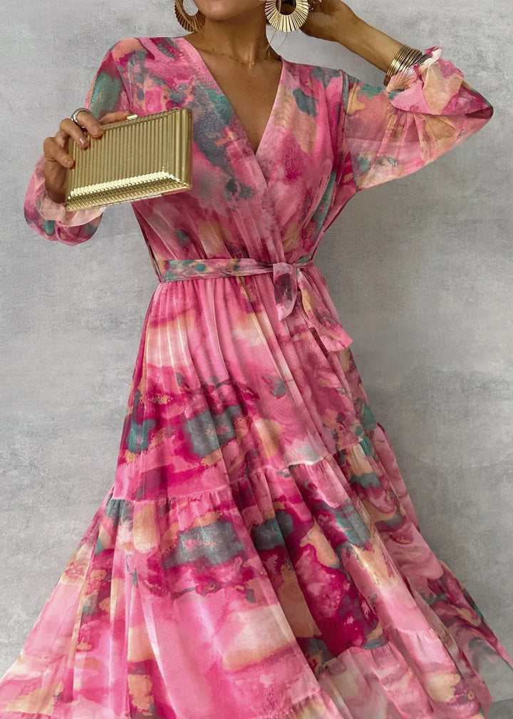 Modieuze roze dames wikkeljurk met vrolijke bloemenprint en comfortabele lange mouwen, een chique keuze.