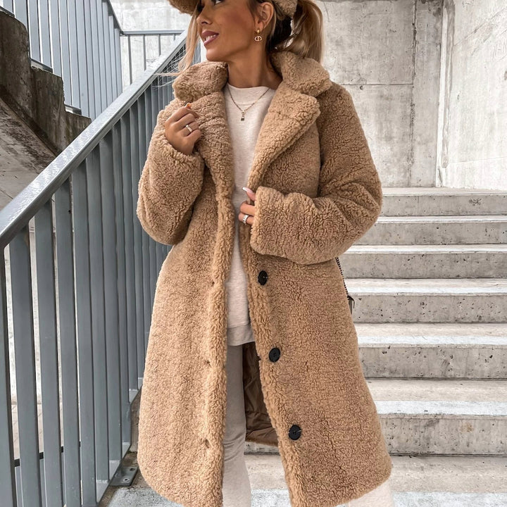 Dames teddybeer winterjas in beige, zachte stof, grote kraag en knoopsluiting.