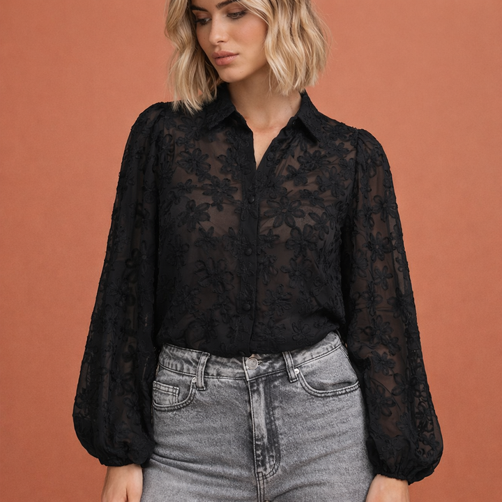 Elegante transparante zwarte damesblouse met fijn bloemenborduursel, ideaal voor feestelijke gelegenheden of avondkleding.