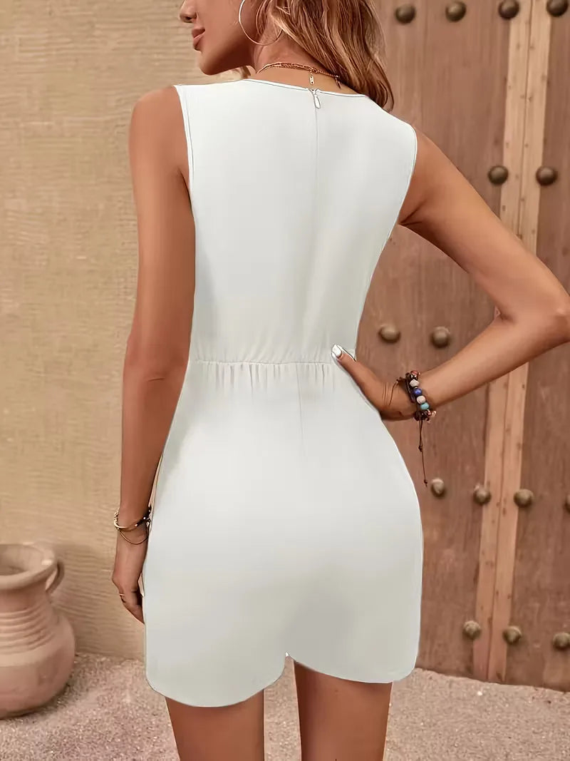 Mouwloze witte dames jumpsuit met V-hals, wijde pijpen en trendy kettingriem. Ideaal voor elegante zomerlooks.