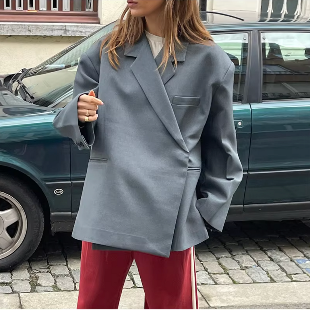 Detail van de stof en knopen van de veelzijdige oversized dames blazer. Hoogwaardige kwaliteit en moderne afwerking.