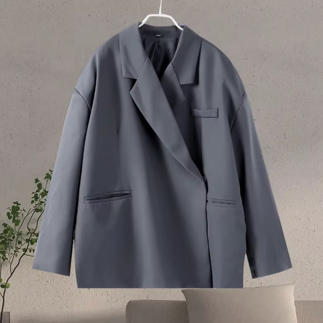 Grijze oversized dames blazer zakelijk gedragen. Perfect voor kantoor of formele evenementen; combineert elegantie met comfort.