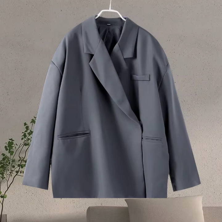 Grijze oversized dames blazer zakelijk gedragen. Perfect voor kantoor of formele evenementen; combineert elegantie met comfort.