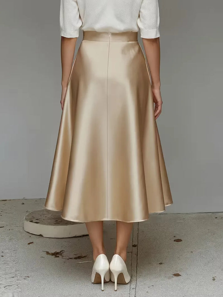 Zachte perzikroze satijnen rok, midi lengte, hoog getailleerd. Ideaal voor lente- en zomer casual.