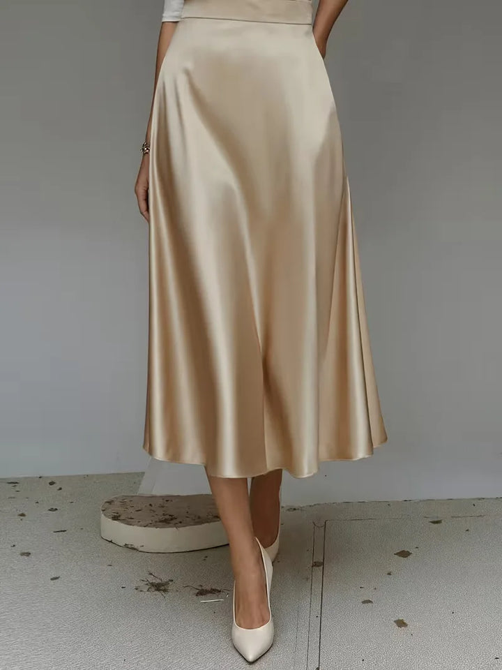 Diepblauwe satijnen dames midirok met hoge taille. Creëert een elegante en verfijnde uitstraling.
