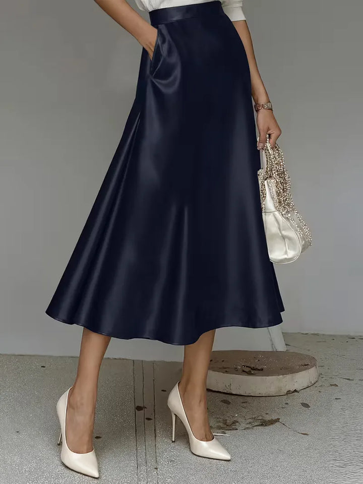 Zwarte satijnen midirok met elegante hoge taille, ideaal voor dames die smart casual kleding waarderen.