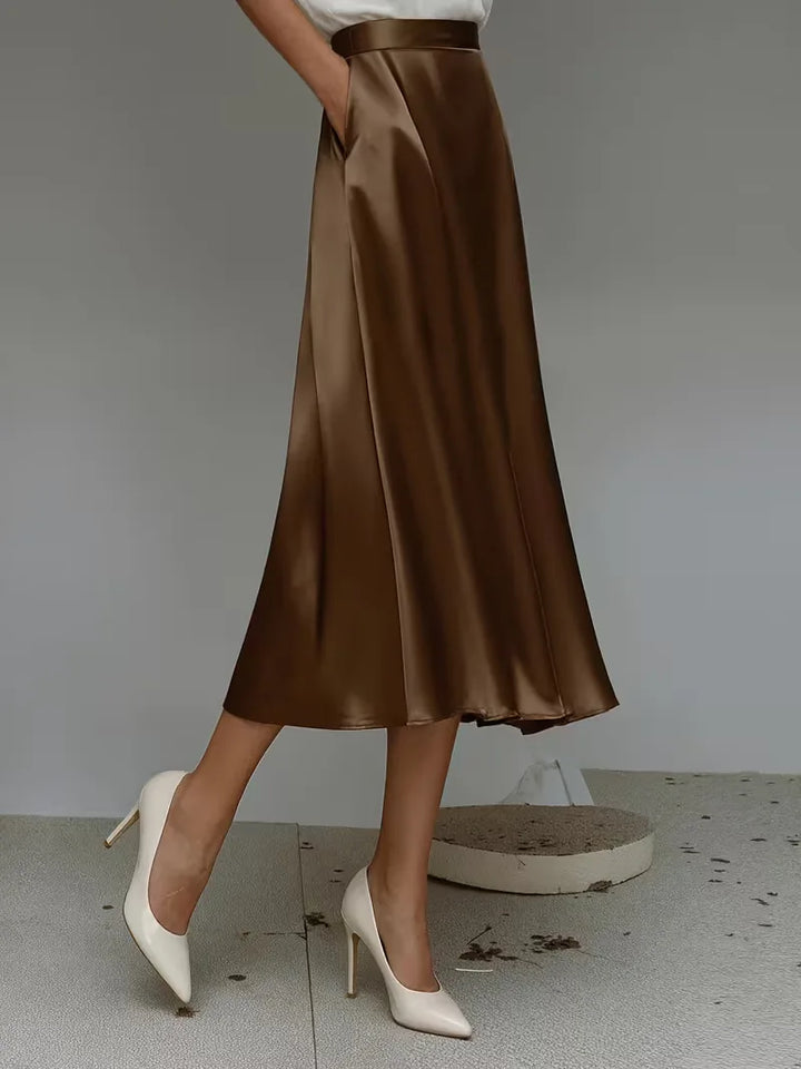 Elegante satijnen rok in aubergine, midi lengte. Hoog getailleerd voor een verfijnde damesstijl.