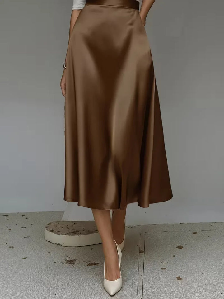 Lichtgrijze satijnen dames midirok met hoge taille. Ideaal voor een minimalistische, elegante outfit.