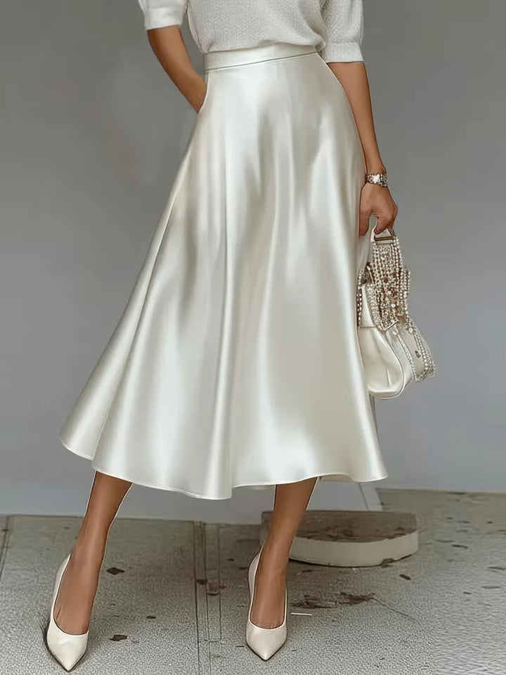 Modieuze satijnen midirok in petrolblauw, hoge taille. Voor een elegante en veelzijdige dameslook.