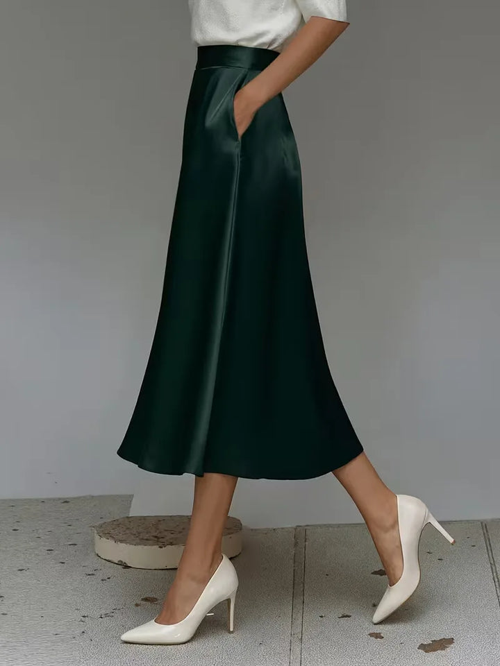 Marineblauwe satijnen midirok, hoogtaille ontwerp, perfect voor een chique en elegante dameslook.