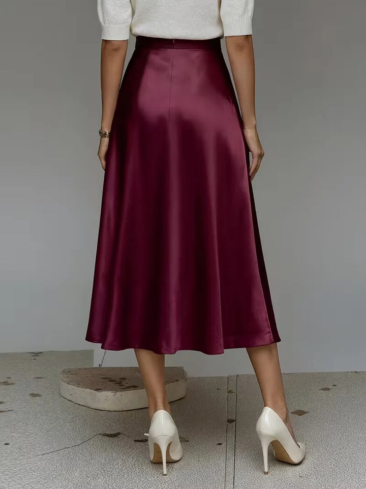 Zilverkleurige satijnen rok met midi lengte en hoge taille. Een elegante keuze voor een moderne dame.