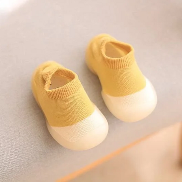 Oranje flexibele kinderschoenen, blotevoetengevoel, ideaal voor eerste stapjes.