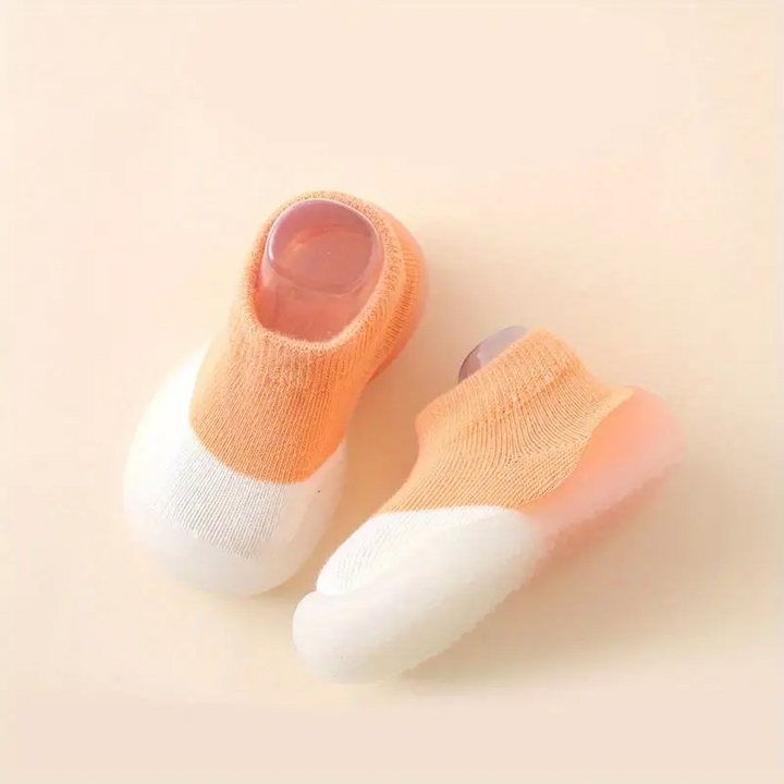 Meerdere kleuren kinderschoenen: blauw, roze, geel, groen, oranje met blotevoetengevoel.