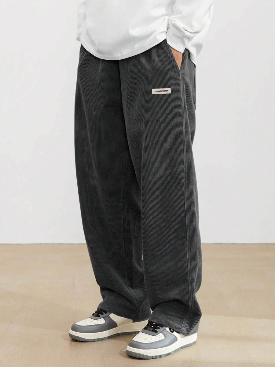 Model draagt een loose-fit heren corduroy broek met rechte pijpen. Comfortabele casual streetwear broek.