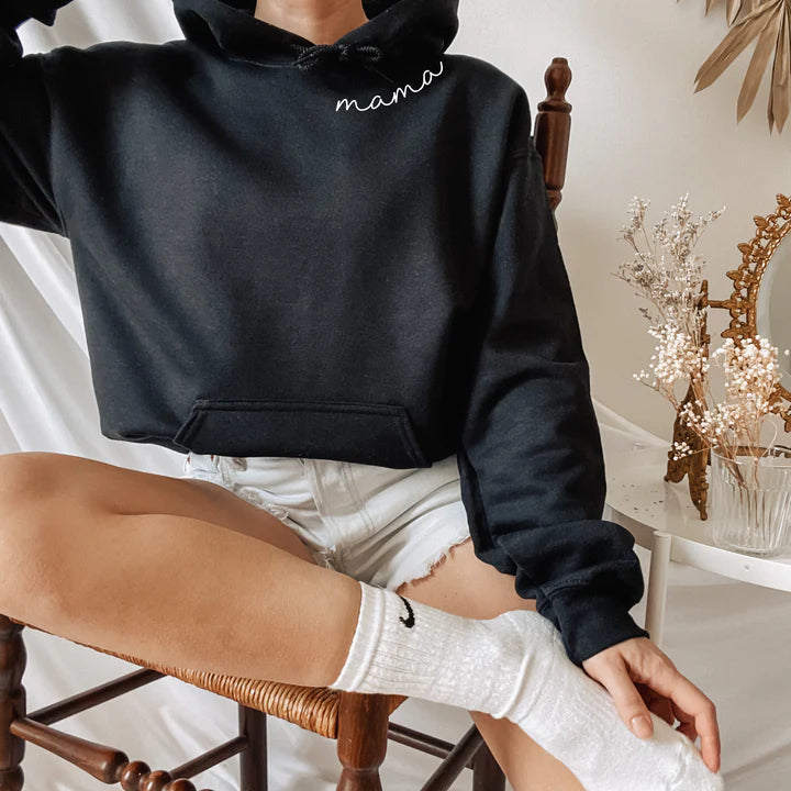 Blije mama draagt zachte gepersonaliseerde hoodie met namen, comfortabel en uniek geschenk.