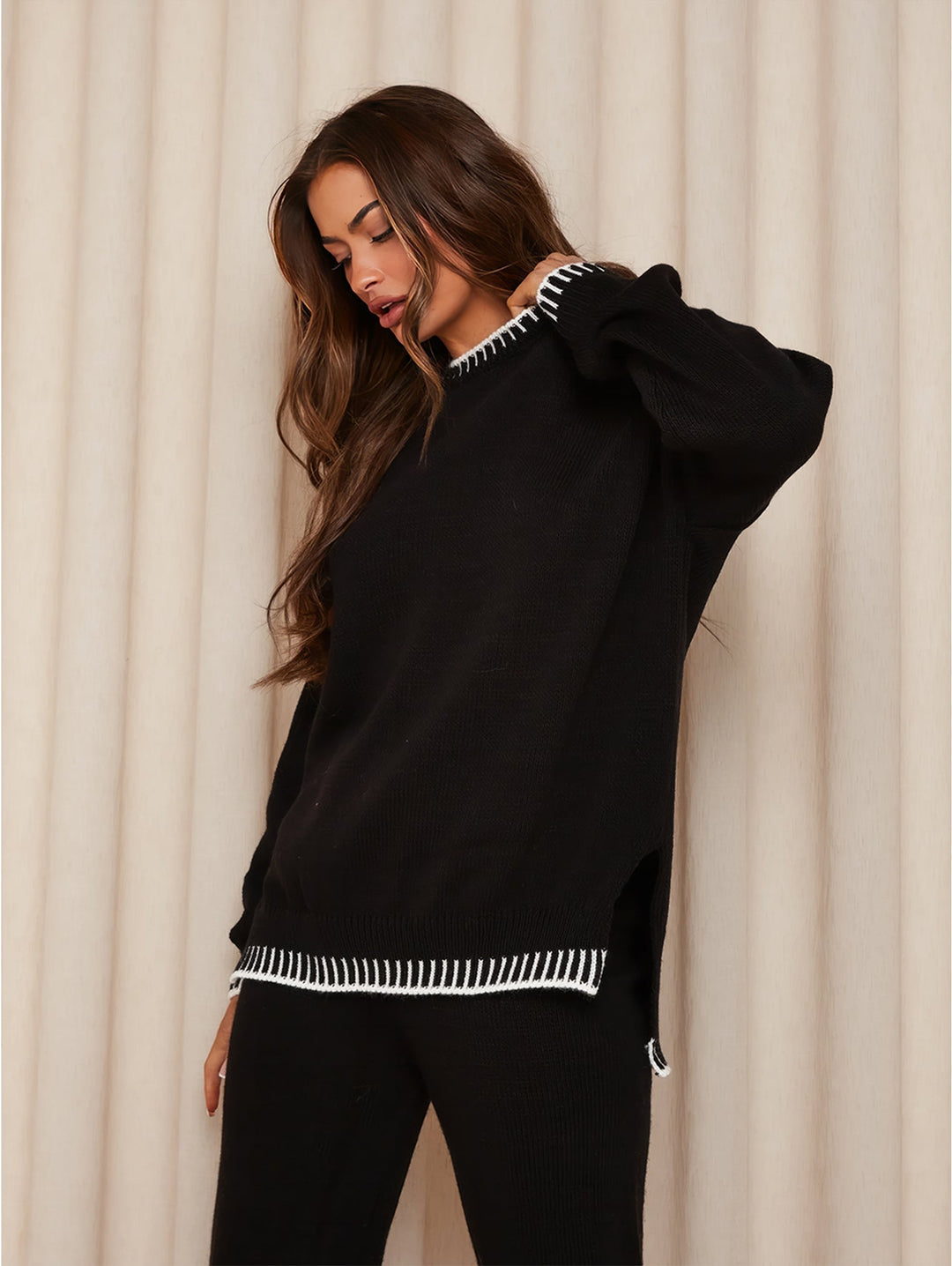 Damesmodel draagt de gestreepte gebreide set, elegant en modieus voor comfortabele winterlooks.