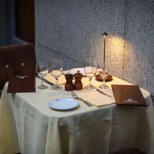 Stijlvolle Glowy oplaadbare LED lamp op een buitentafel, sfeerlicht, donkere achtergrond.