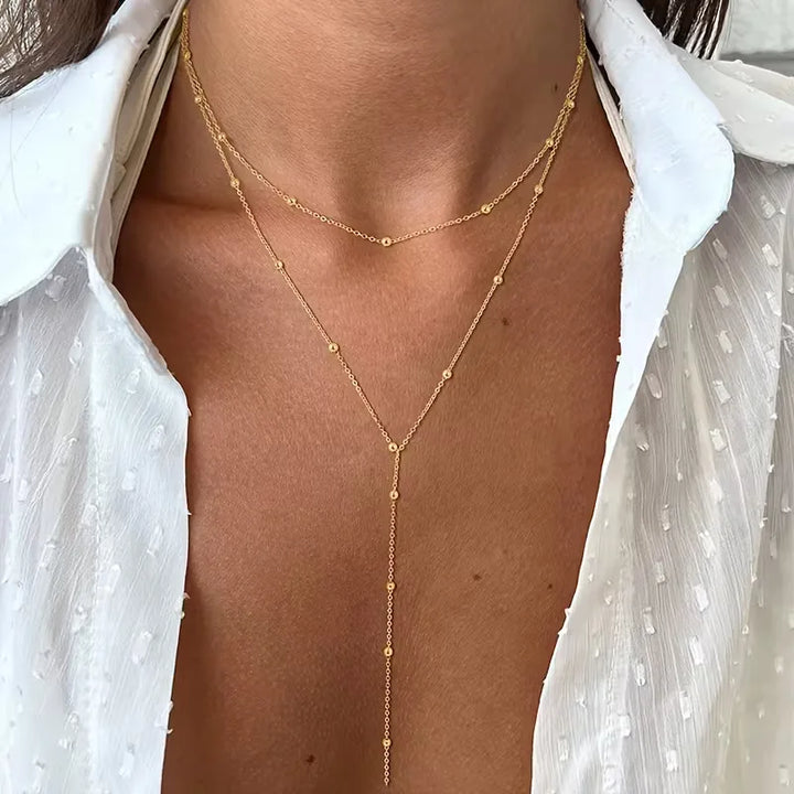 Damesketting van goud met rijstparels, voorzien van elegante franjes. Een dubbellaags design voor een chique uitstraling.