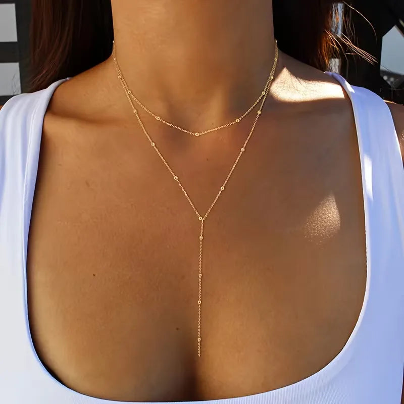 Verfijnde gouden damesketting, handgemaakt met echte rijstparels en delicate franjes. Tijdloos en elegant.