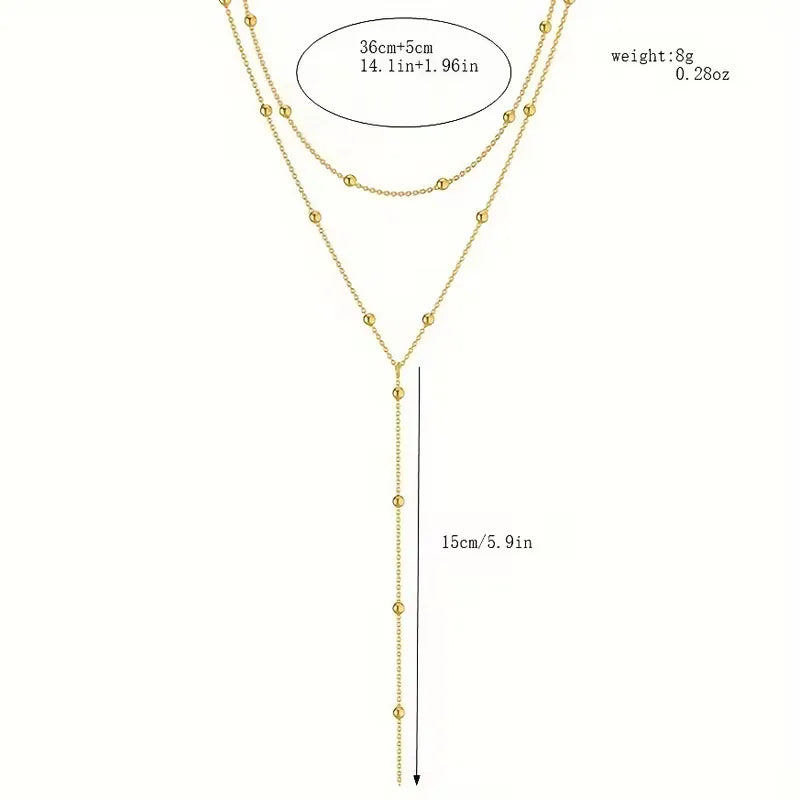 Chique damesketting in goudkleur met natuurlijke rijstparels en sierlijke franjes. Een trendy accessoire.