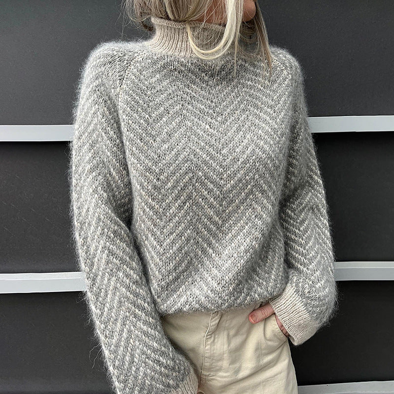 Grijze dames coltrui met hoge hals en elegant visgraatpatroon voor wintermode, comfortabel en ontspannen pasvorm.