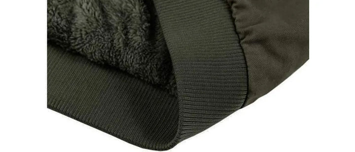 Details van de zakken en mouwboorden van dit robuuste heren winter bomberjack.