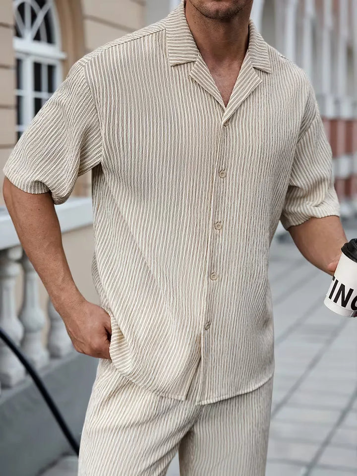 Casual heren zomer outfit: beige V-hals shirt en stijlvolle krijtstreep broek. Geschikt voor elke man.