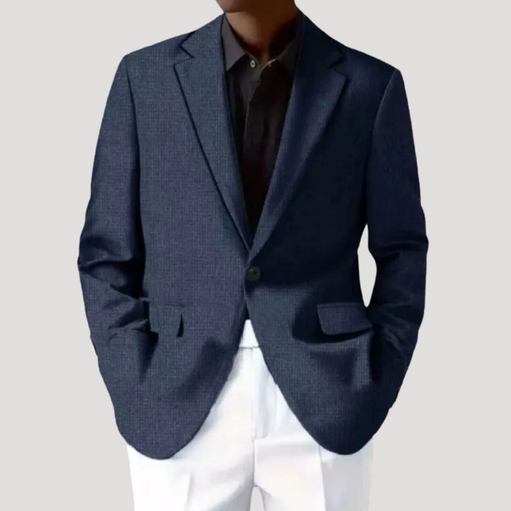 Model draagt getailleerde heren blazer, gecombineerd voor een complete zakelijke of nette outfit.