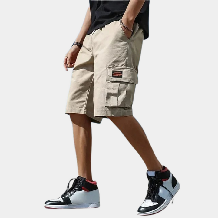 Detail van de functionele klepzak op een heren cargoshort van groen katoen, perfect voor elke outfit.