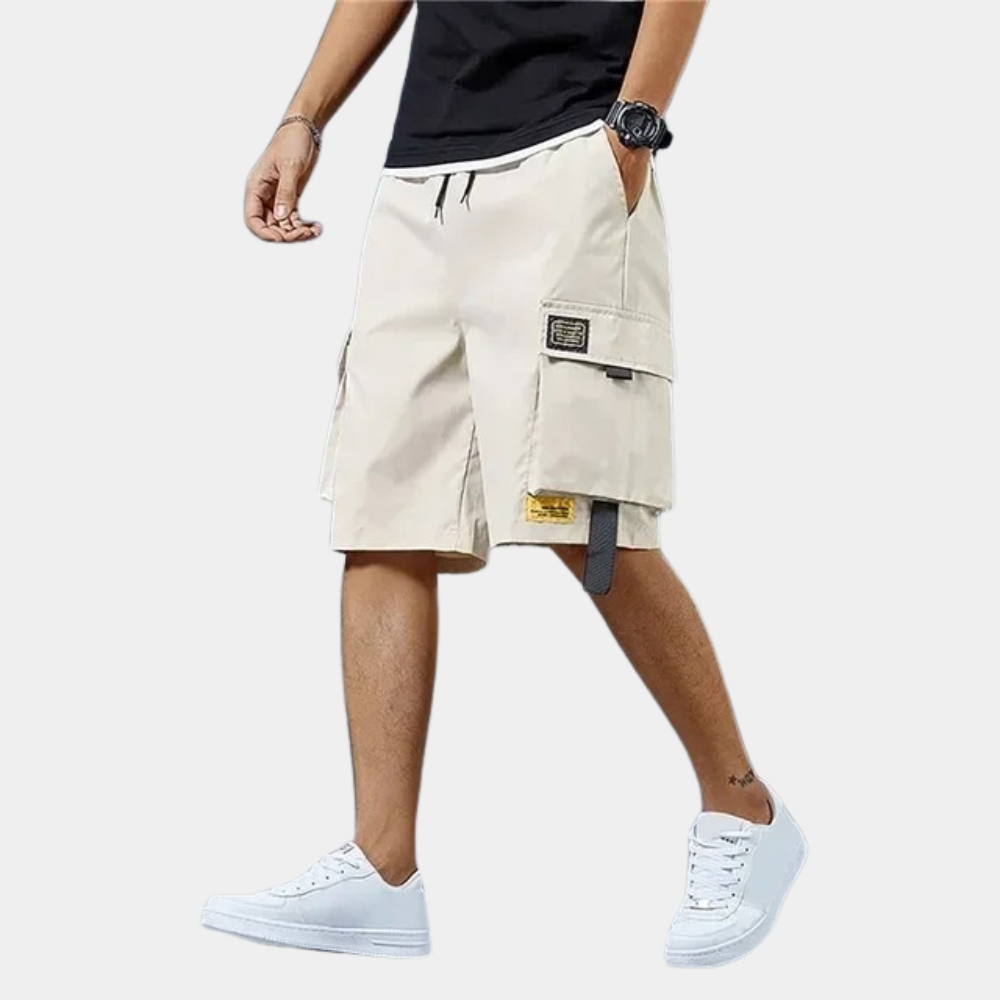 Model draagt blauwe katoenen cargoshorts voor heren, stijlvol en comfortabel voor alle zomeractiviteiten.